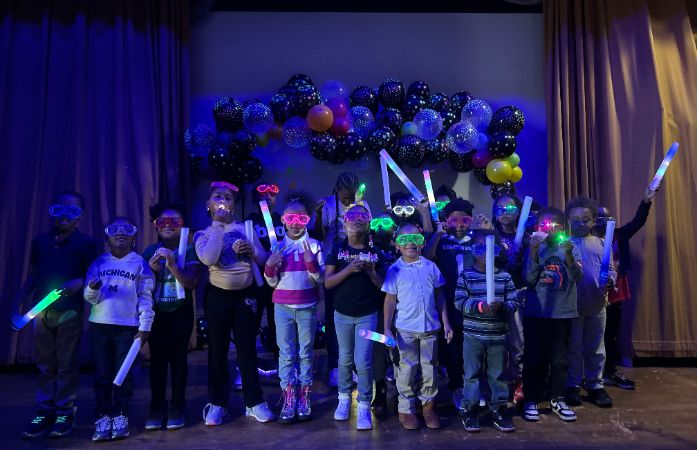  students standing with glow in the dark sticks and glasses